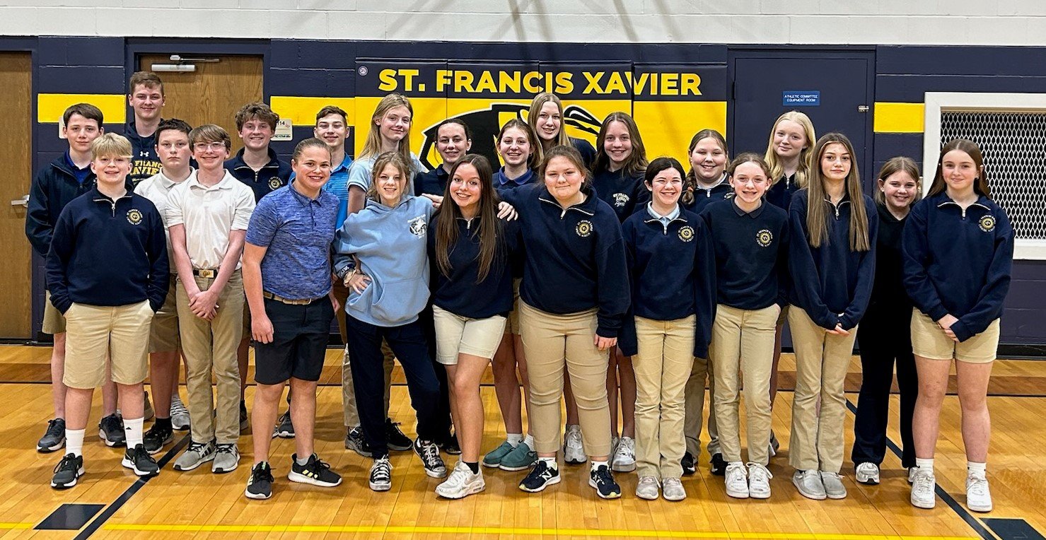 Students at St. Francis Xavier School in Taos gather in the gym after signing, addressing and mailing 700 invitations for people to come back to Mass if they’ve been away.